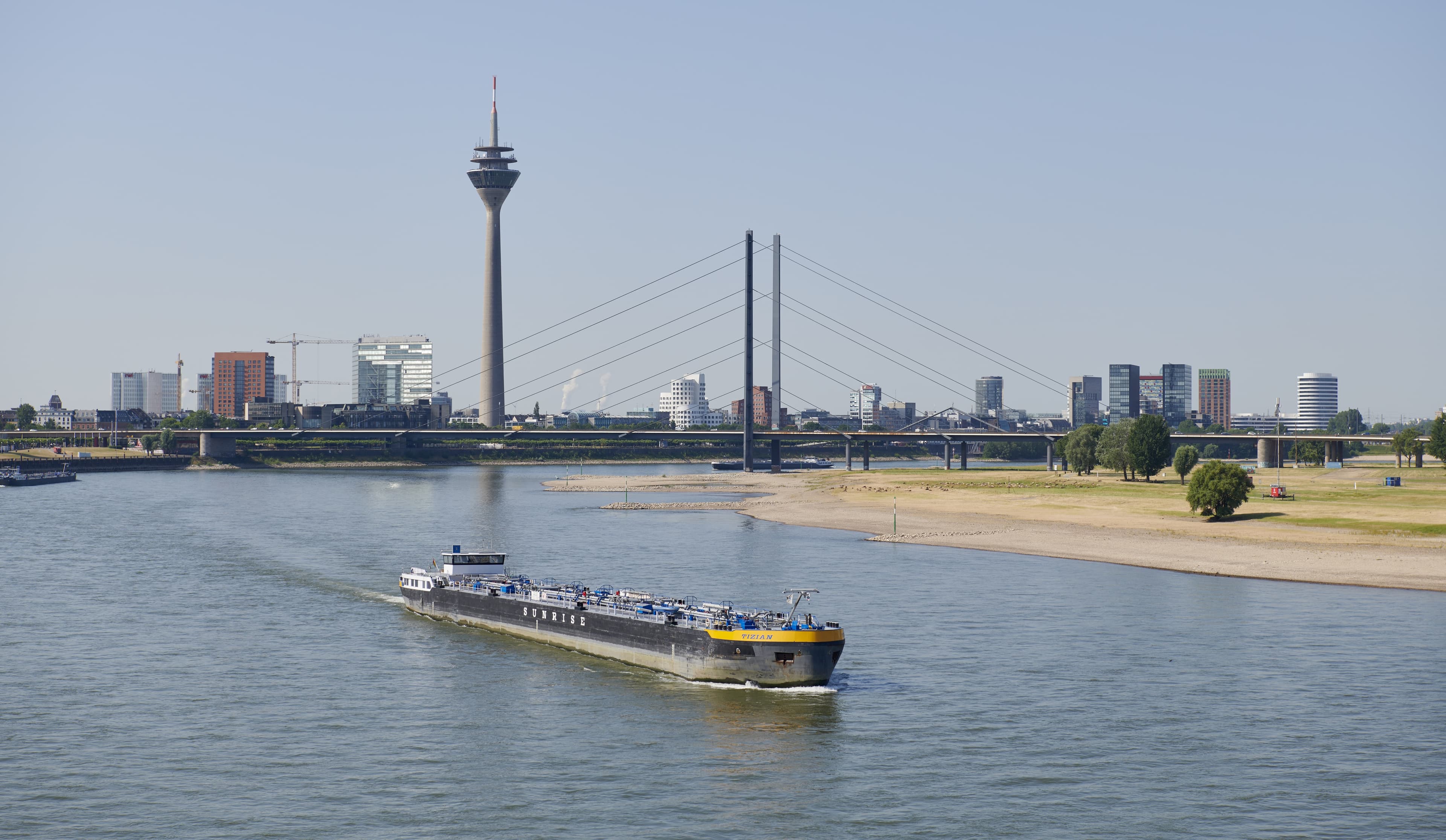 Aufnahme vom Rhein in Düsseldorf. Ein Tanker fährt auf dem Rhein und im Hintergrund steht der Fernsehturm.